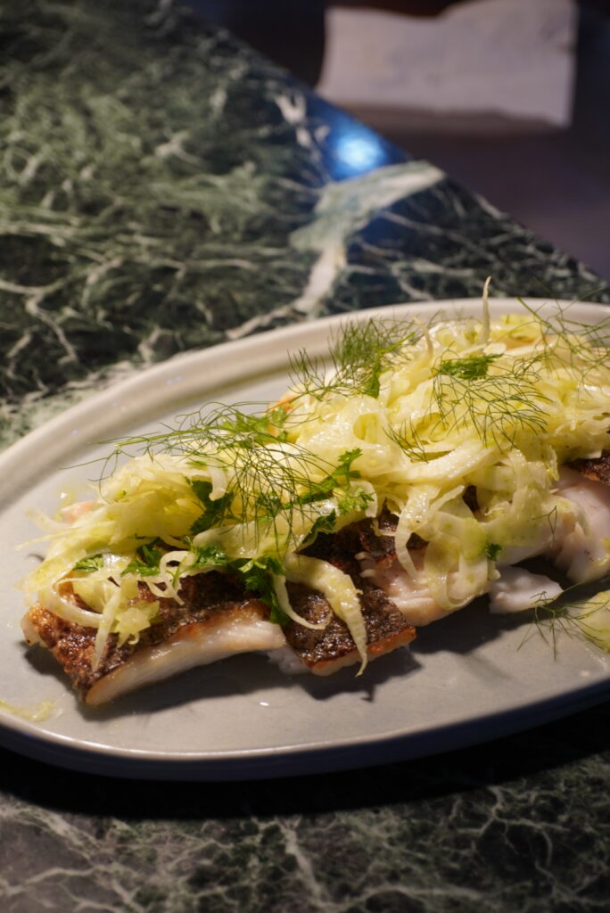 Fish with shaved fennel on a marble table at Megalong