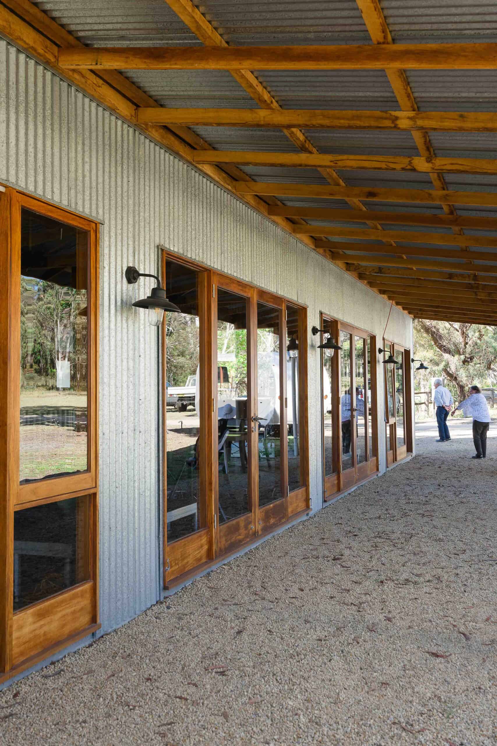 Exterior view of a modern building with large glass doors and wooden frames at Megalong Valley Music.
