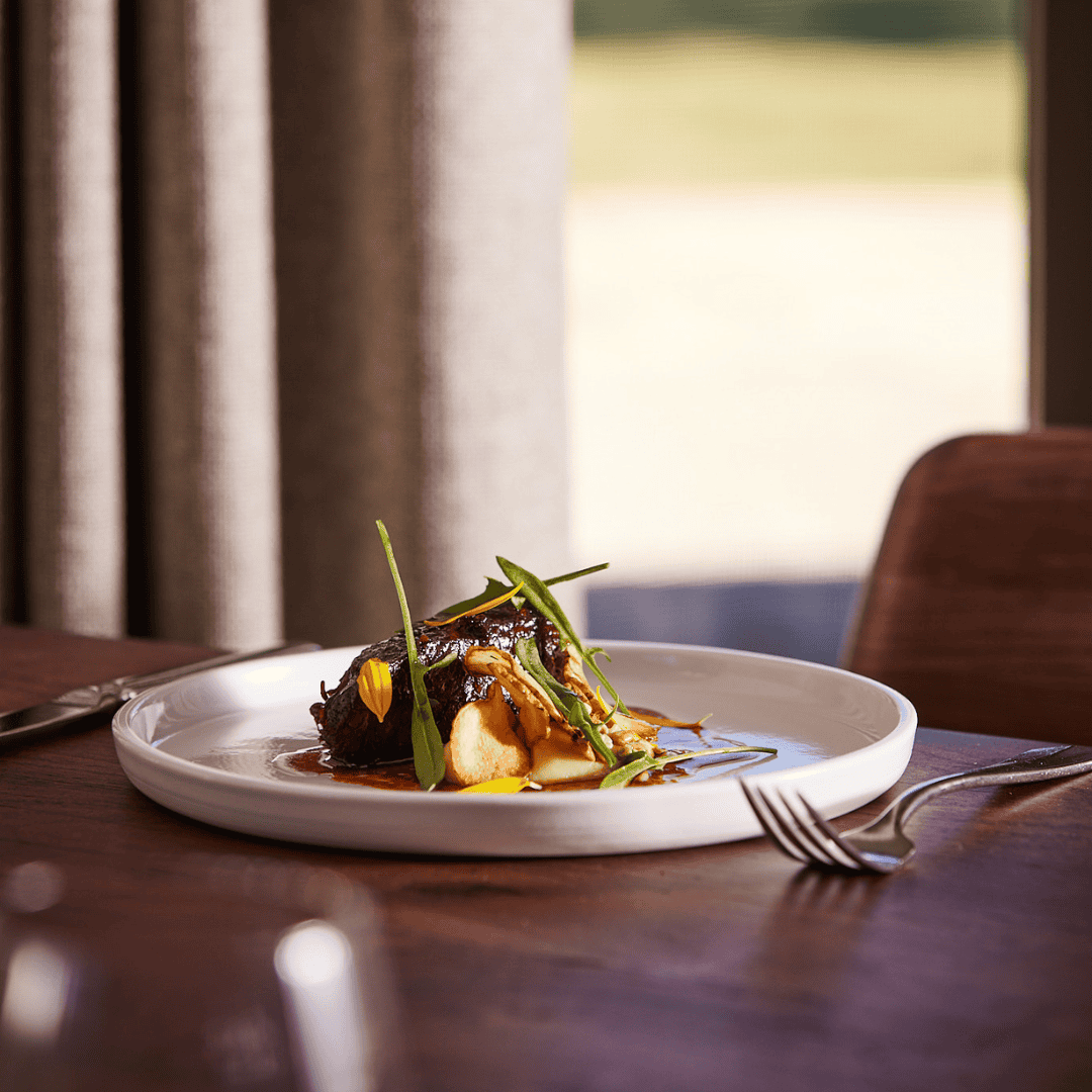 Elegant plated gourmet dish with greens and sauce at LOT 101 staging.
