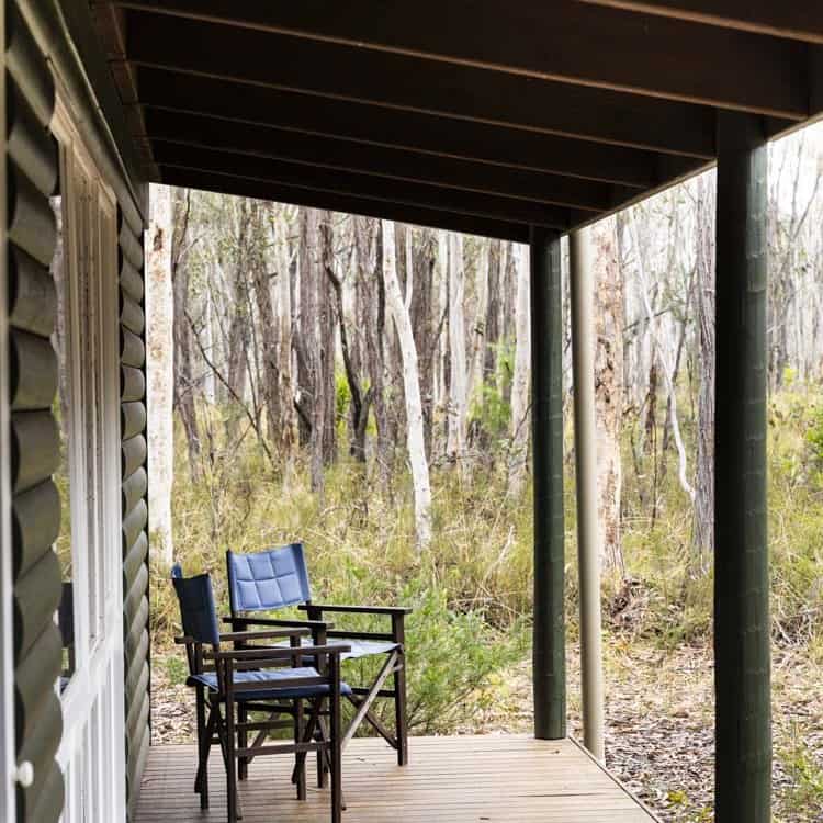 Outdoor deck with chairs overlooking wooded area at LOT 101.