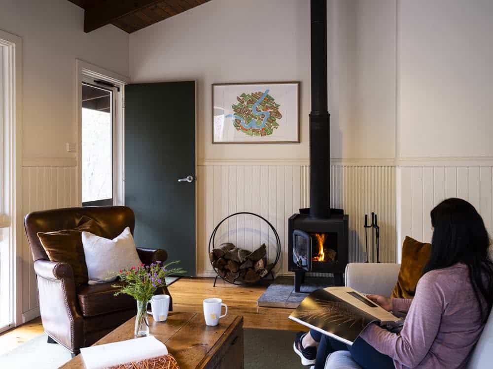 Interior of a cozy living room with a wood-burning fireplace and comfortable seating.