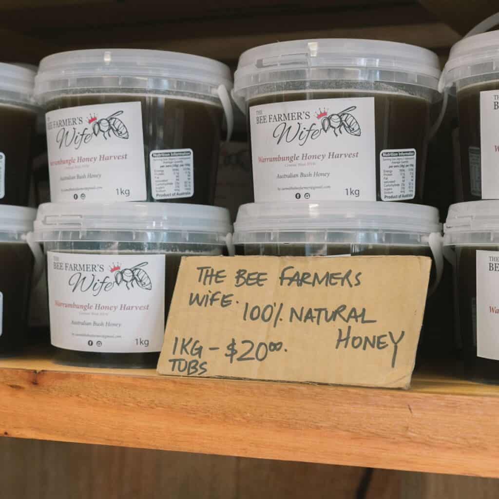 Containers of Kermanghunge honey with a handwritten sign for sale.