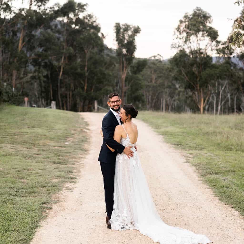 Happy bride and groom embracing outdoors at LOT 101 wedding venue.