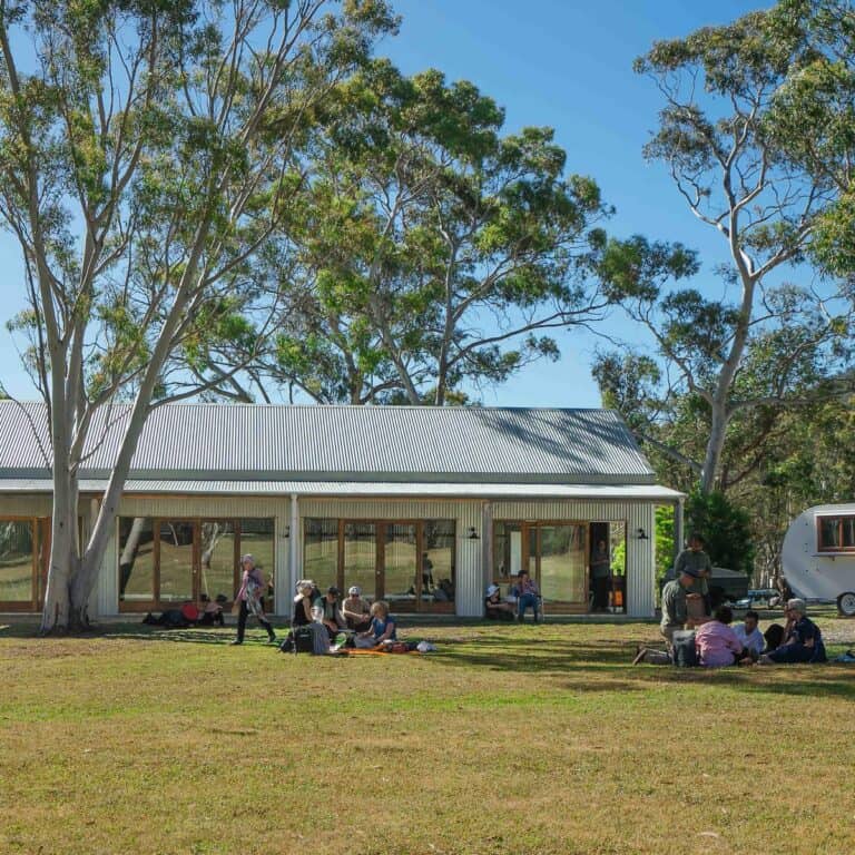 People gathering outdoors at LOT 101 with trees and a building in the background.