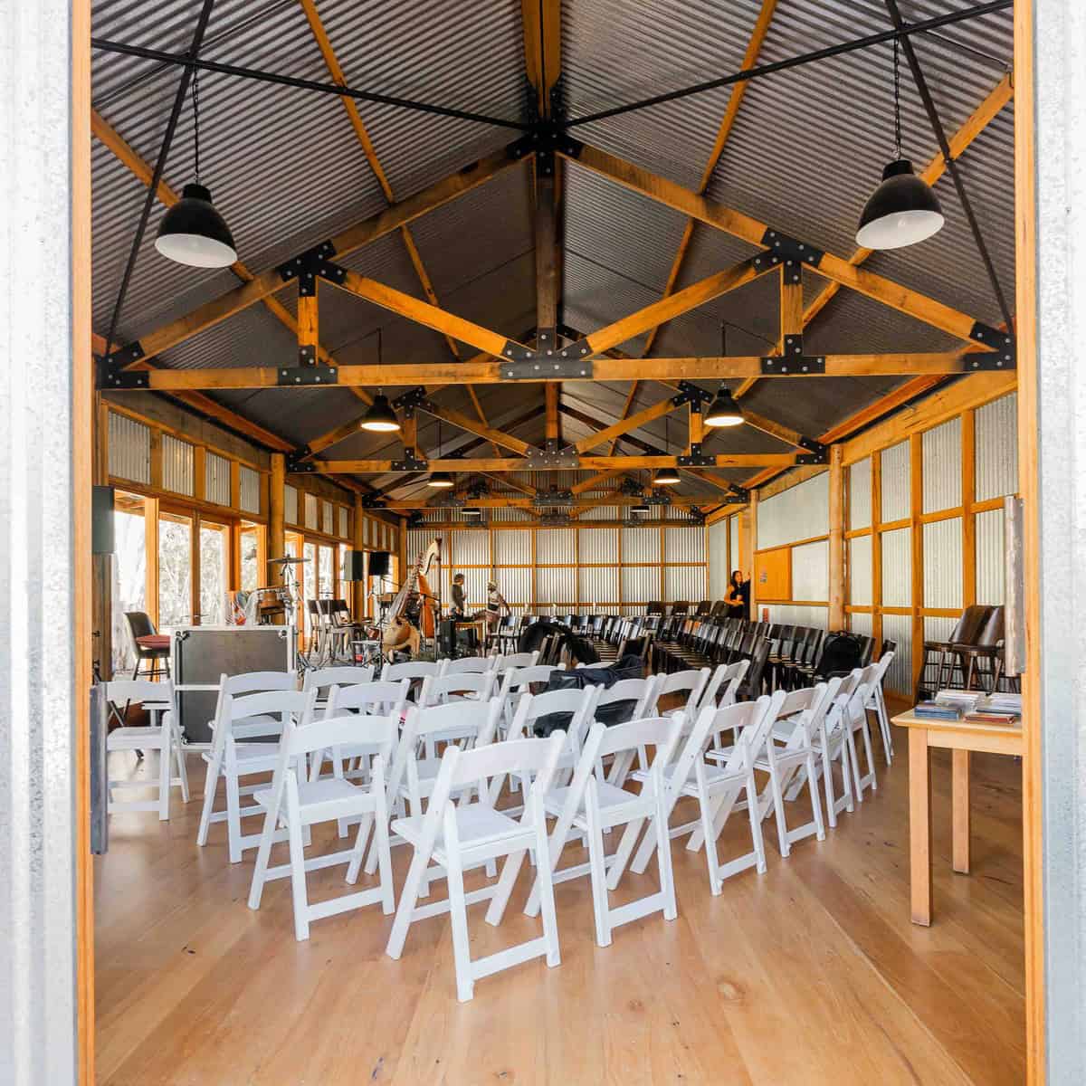 Indoor event space with white chairs and stage for wedding or function.